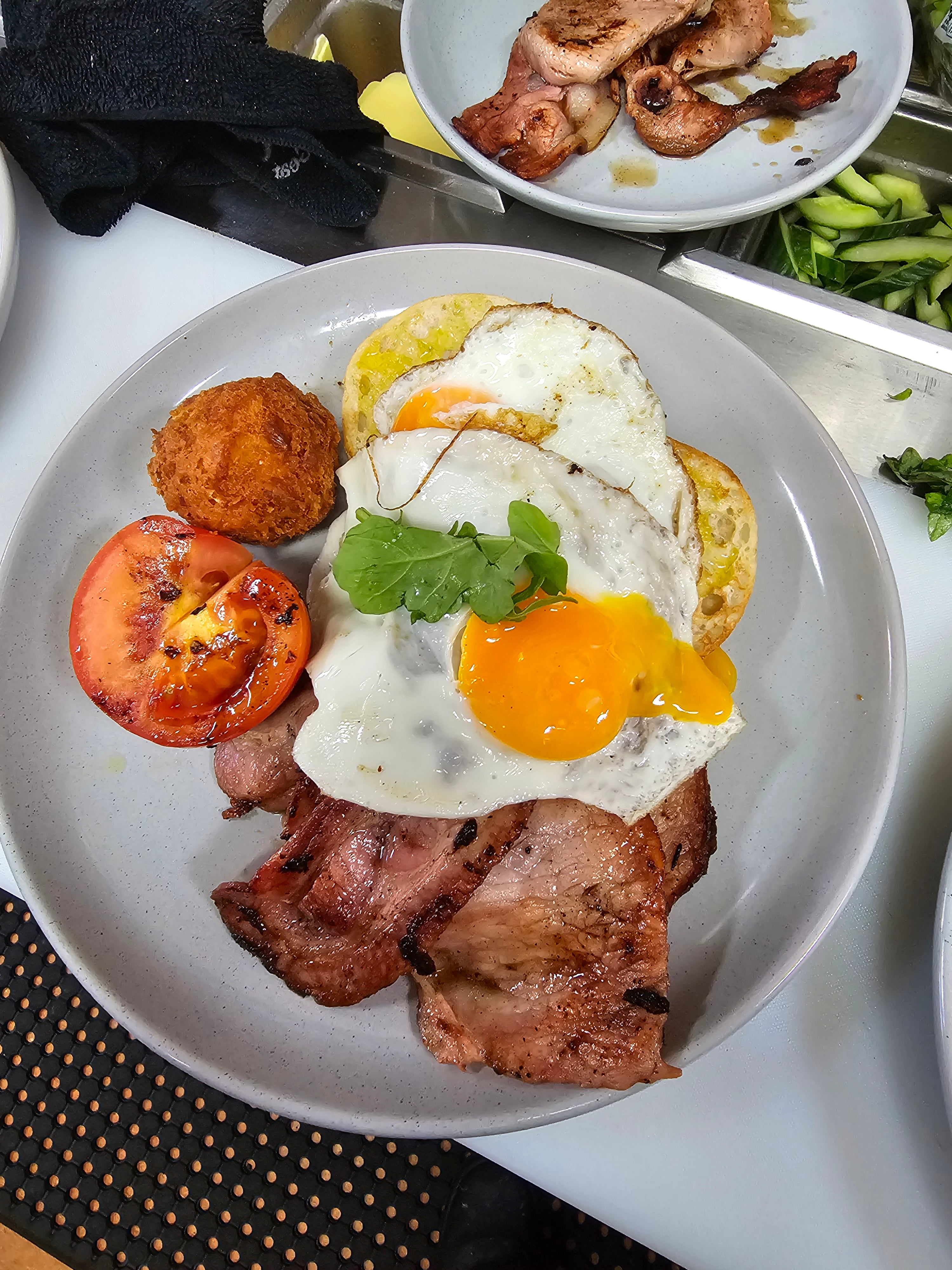 Barn Yard Breakfast with eggs, crispy bacon, grilled tomato, homemade hash brown, and toasted Turkish bread at The Social Cafe in Emerald QLD 4720.