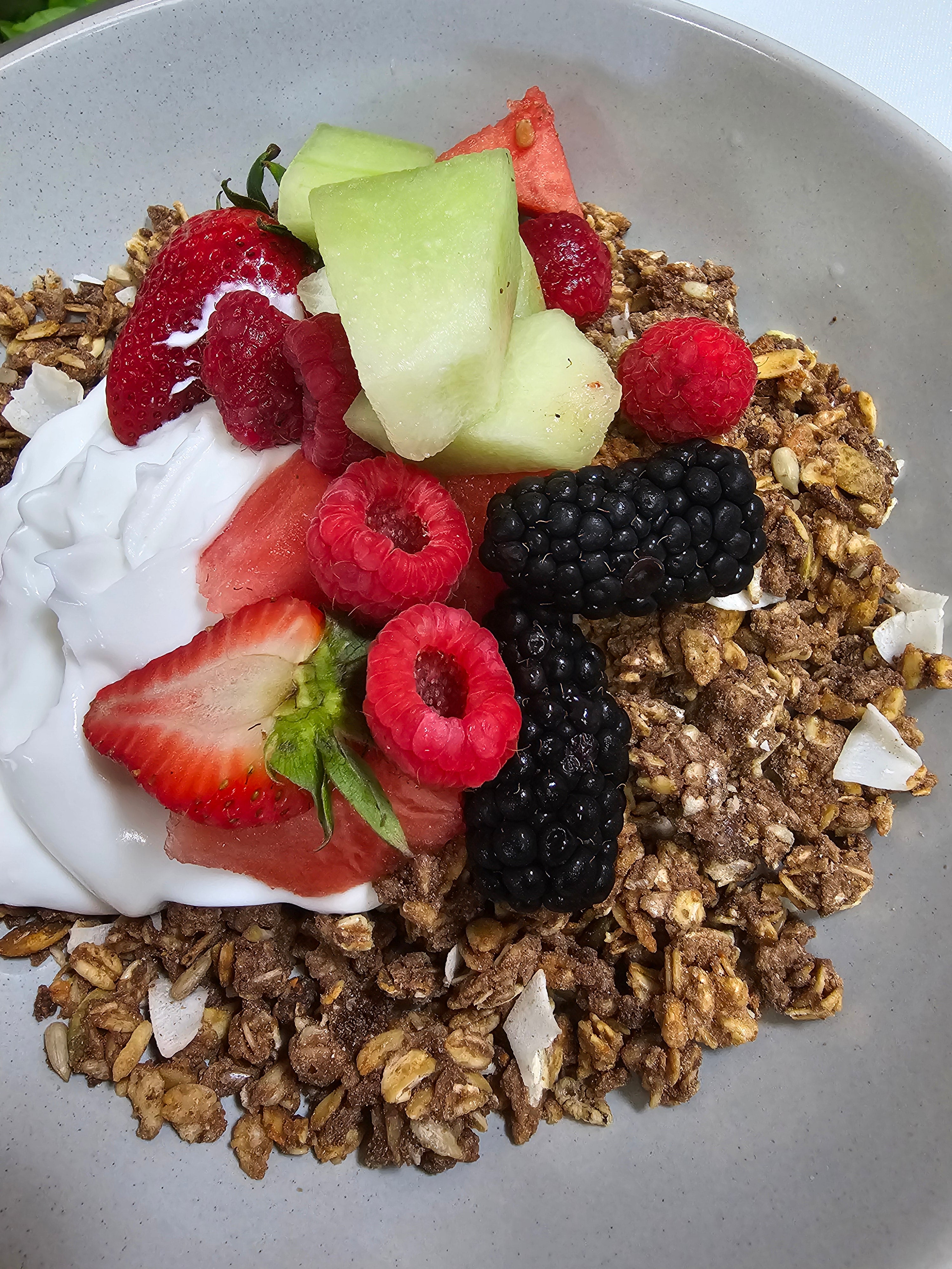Wholesome granola with creamy coconut yogurt, fresh seasonal fruits, and berry coulis from The Social Cafe in Emerald QLD 4720.
