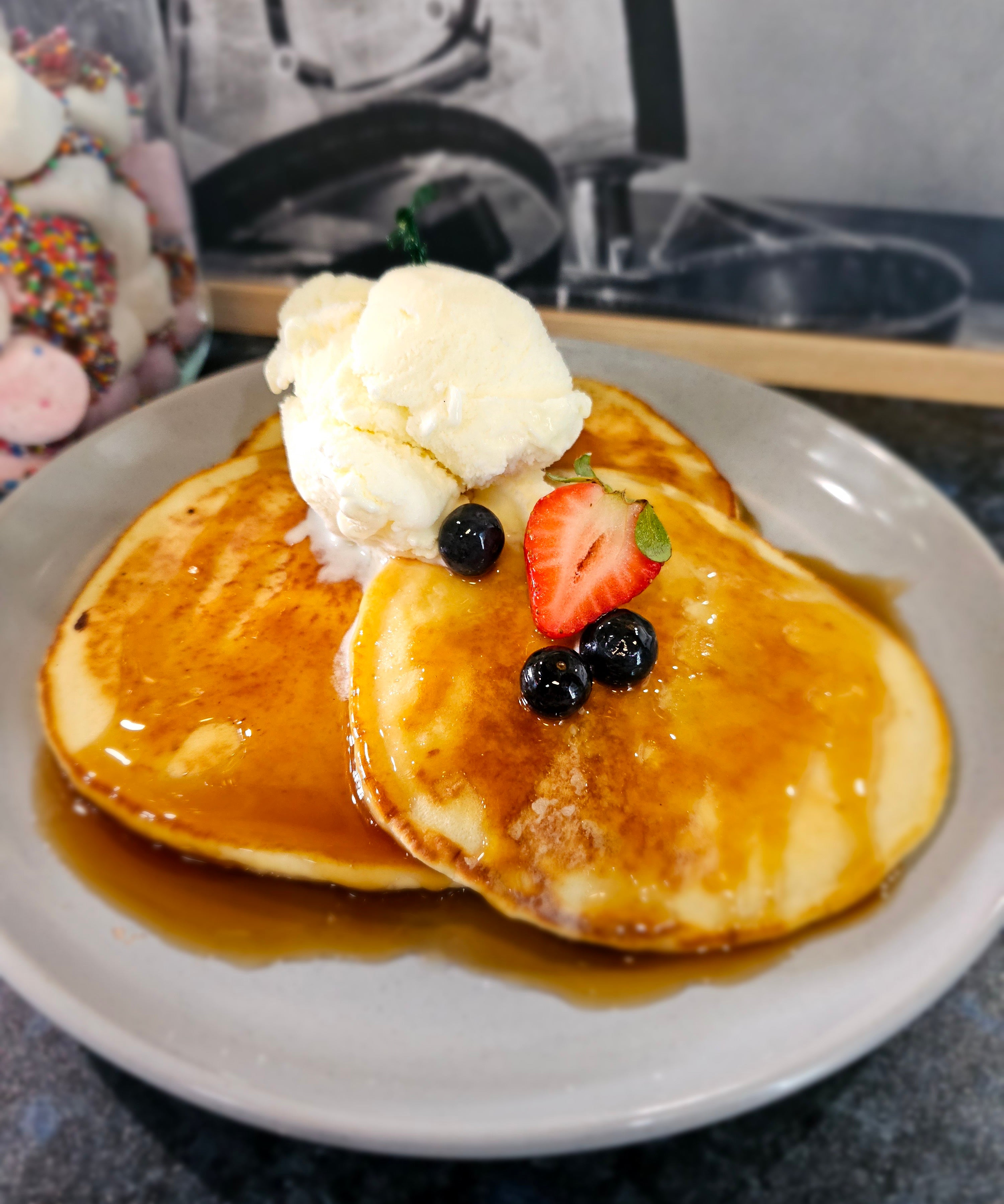 Trio of fluffy pancakes with maple syrup and ice cream from The Social Cafe in Emerald QLD 4720.