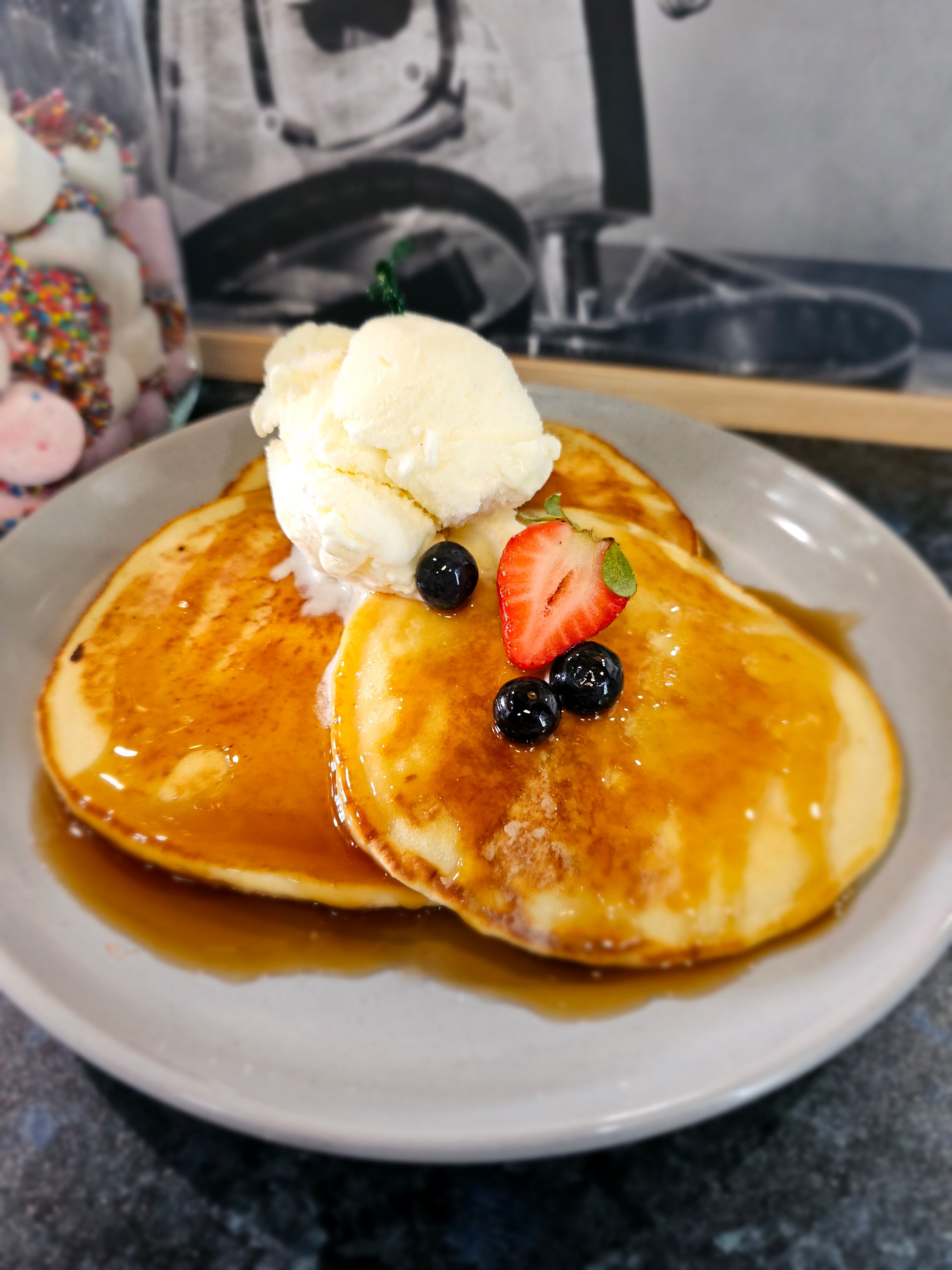Trio of fluffy pancakes with maple syrup and ice cream from The Social Cafe in Emerald QLD 4720.